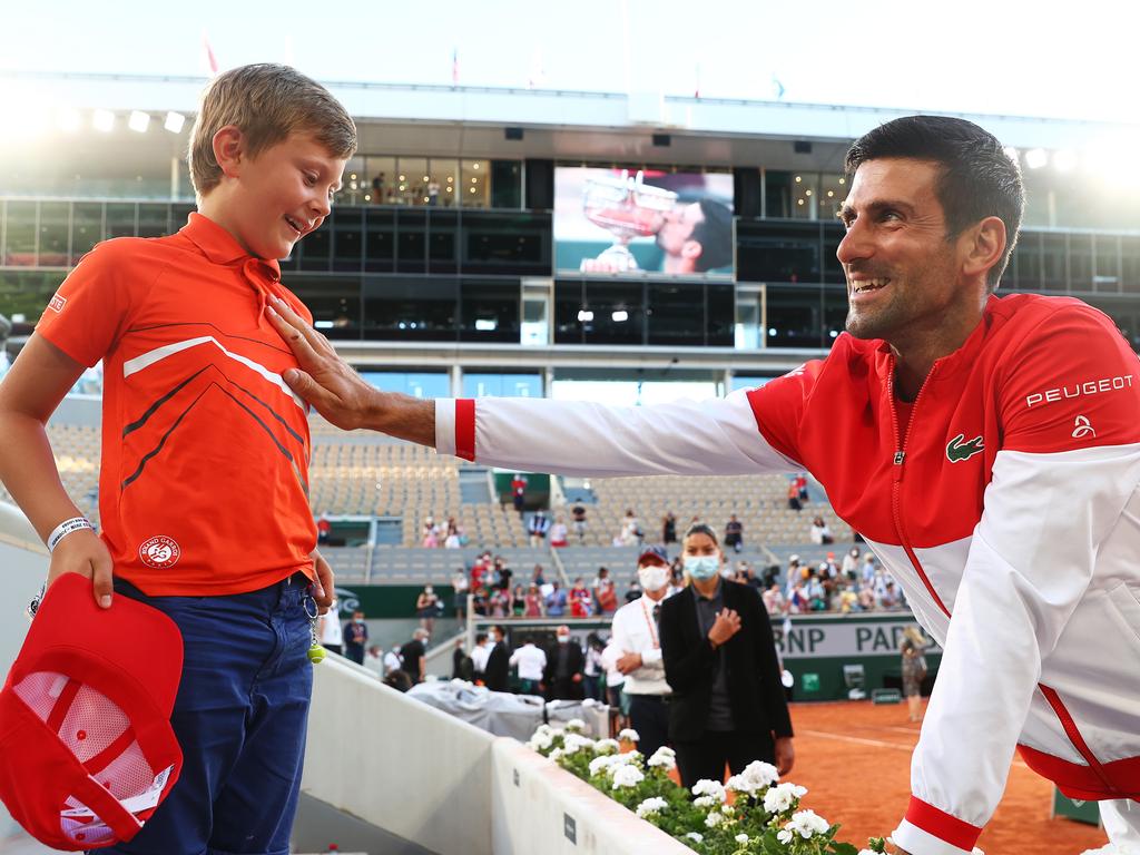 Novak Djokovic celebrates with a young fan. Getty Images.