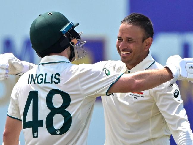 Australia's Usman Khawaja (R) celebrates with his teammate Josh Inglis after scoring a double century (200 runs) during the second day of the first Test cricket match between Sri Lanka and Australia at the Galle International Cricket Stadium in Galle on January 30, 2025. (Photo by Ishara S. KODIKARA / AFP)