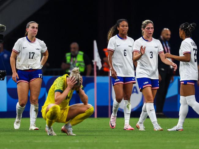 Australia's defender #14 Alanna Kennedy reacts as US' players celebrate at the end of the women's group B football match between Australia and the USA of the Paris 2024 Olympic Games at the Marseille Stadium in Marseille on July 31, 2024. (Photo by Pascal GUYOT / AFP)