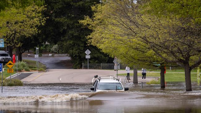 Two men who drove their car through flood waters near the junction of the Macalister, Thompson and La Trobe rivers unnecessarily receive a talking too from Fire Rescue. Picture: Jason Edwards