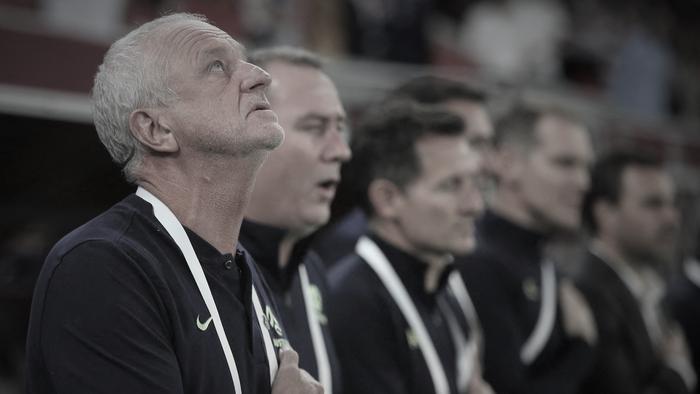 Australia's coach Graham Arnold (L) and his staff sing the national anthem ahead of the FIFA World Cup 2022 inter-confederation play-offs match between Australia and Peru on June 13, 2022, at the Ahmed bin Ali Stadium in the Qatari city of Ar-Rayyan. (Photo by MUSTAFA ABUMUNES / AFP)