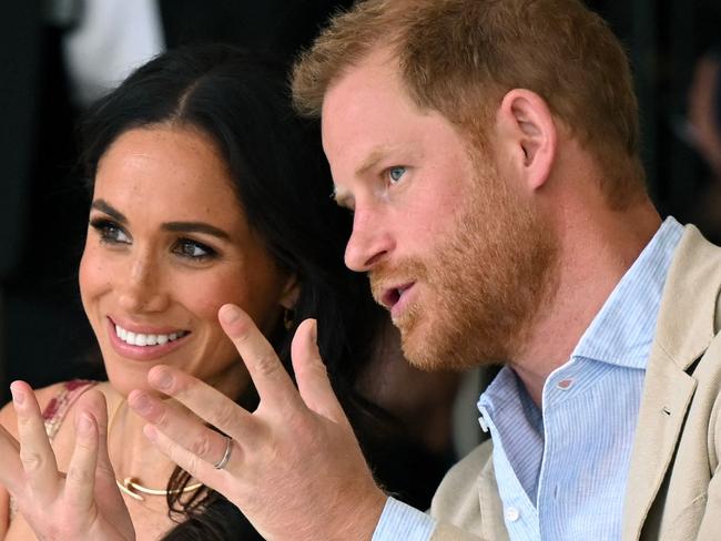 Britain's Prince Harry (R), Duke of Sussex, speaks with his wife Meghan Markle while attending a show during a visit to the National Centre for the Arts in Bogota on August 15, 2024. Prince Harry and his wife, American actress Meghan Markle, arrived in Colombia at the invitation of vice President Francia Marquez, with whom they will attend various meetings with women and young people to reject discrimination and cyberbullying. (Photo by RAUL ARBOLEDA / AFP)