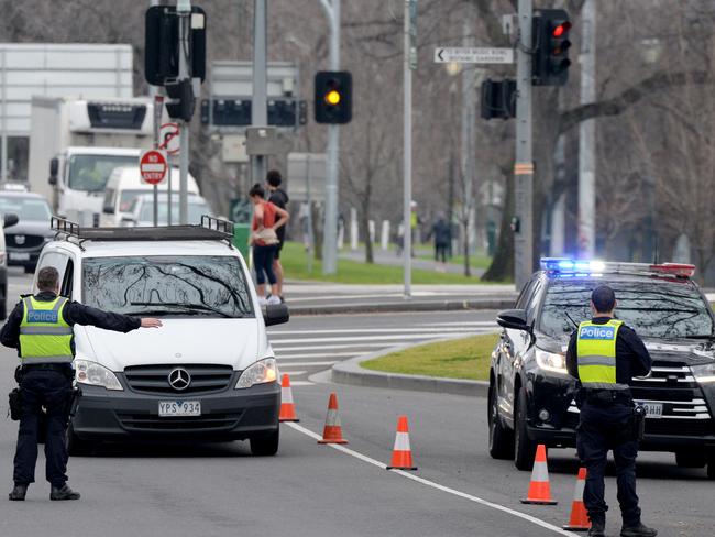 Police inspect drivers' ID at a random checkpoint set up on Alexandrea Ave, South Yarra. Picture: Andrew Henshaw