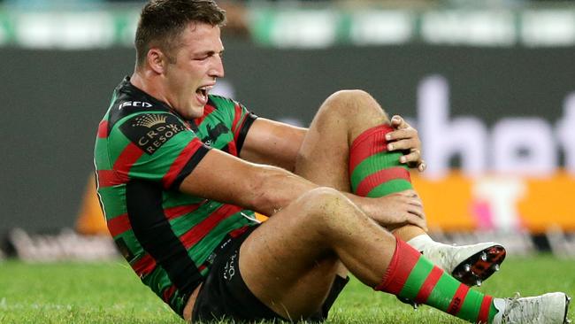 Burgess grabs at an injured ankle during the Rabbitohs defeat to the Tigers.