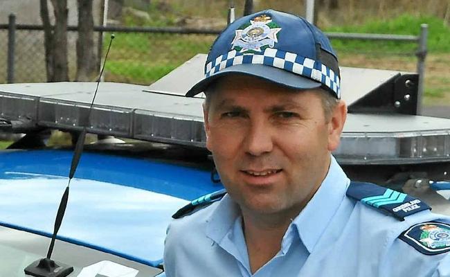 Sergeant Shane Reid with one of the white-ribbon clad police vehicles. . Picture: Emma Channon