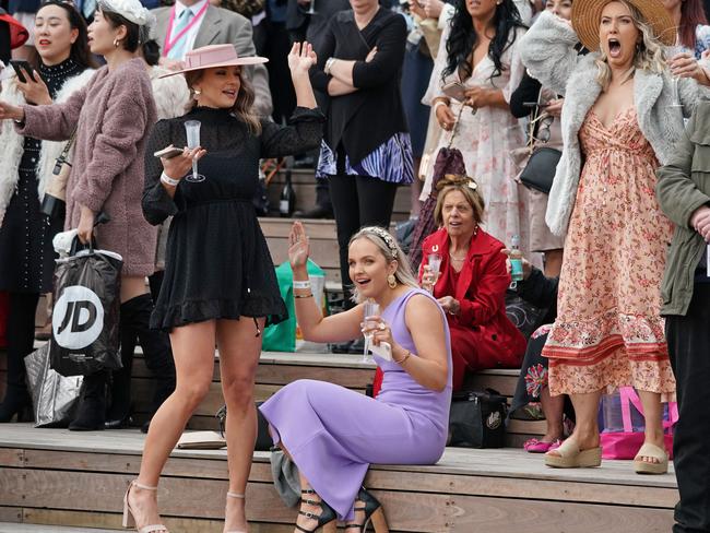 Racegoers celebrate as they watch a race during Oaks Day. Picture: AAP Image/Scott Barbour