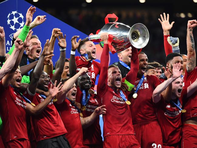 TOPSHOT - Liverpool's English midfielder Jordan Henderson raises the European Champion Clubs' Cup as he celebrates with teammates after winning the UEFA Champions League final football match between Liverpool and Tottenham Hotspur at the Wanda Metropolitano Stadium in Madrid on June 1, 2019. (Photo by GABRIEL BOUYS / AFP)