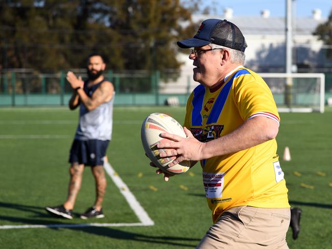 Prime Minister Scott Morrison joins a rugby league drill with students from the Clontarf Academy at Endeavour Sports High School in Sydney. (AAP Image/Joel Carrett)