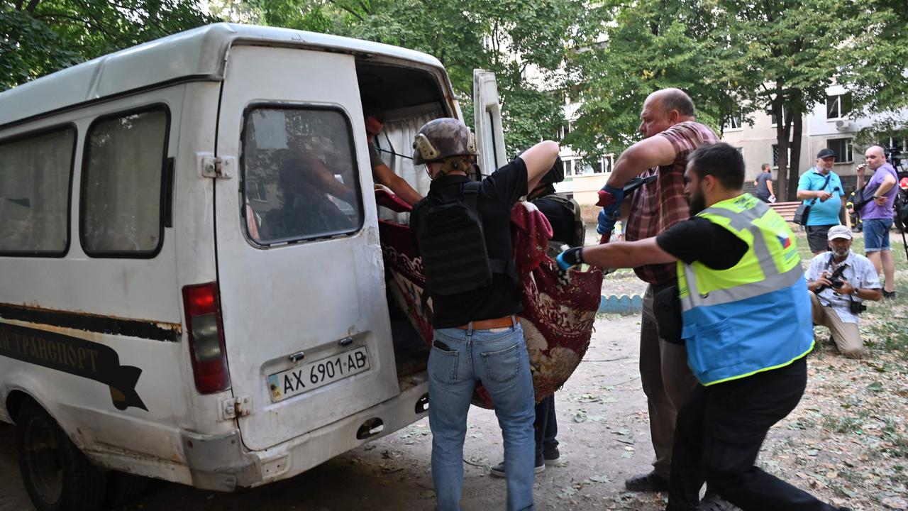 Volunteers load the body of a killed person into a car following the attack. Picture: Sergey Bobok/AFP