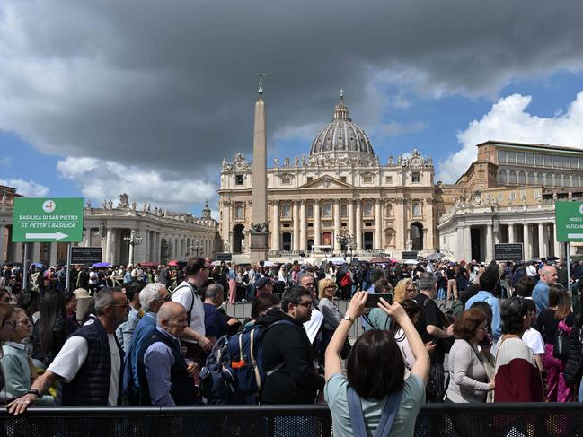 A pedestrian takes a picture as visitors queue to access St Peter's Basilica. Picture: AFP