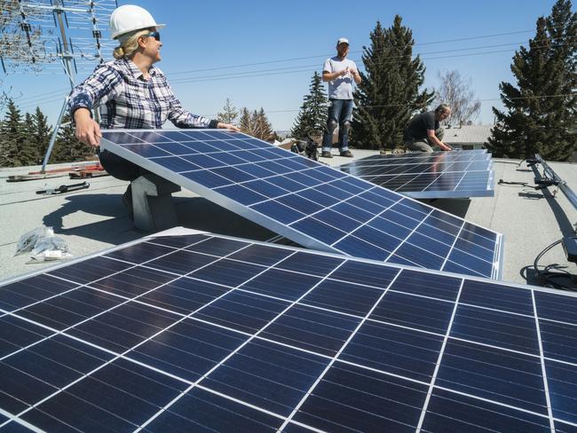 Workers installing solar panels on a residential homes roof.