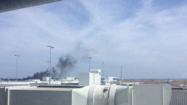 Thick black smoke visible from one of the terminals at Sydney Airport. Picture: Twitter