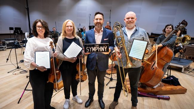 TasPlates CEO David McGrath (second from right in the front) with TSO musicians (from left to right) Anna Larsen Roach, Lucy Carrig-Jones and David Robins (with Aurora Henrich on double bass (right) and other musicians in the background. Picture Caleb Miller.