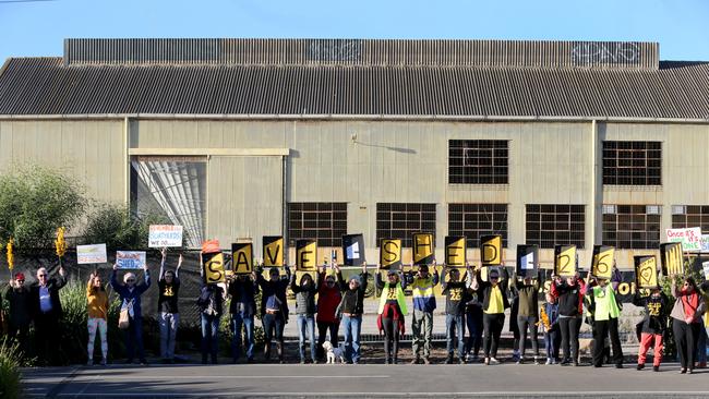 Members of the public hold placards during a protest against the demolition of Shed 26. Picture: Kelly Barnes/AAP