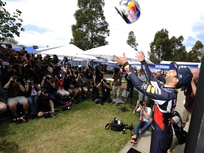Red Bull driver Daniel Ricciardo of Australia throws his helmet in the air during the driver photo session ahead of the Australian Formula One Grand Prix at Albert Park in Melbourne, Australia, Thursday, March 12, 2015. (AP Photo/Ross Land)