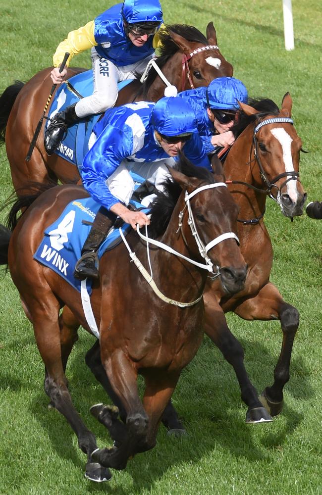 Winx strides past Hartnell. Picture: Tony Gough