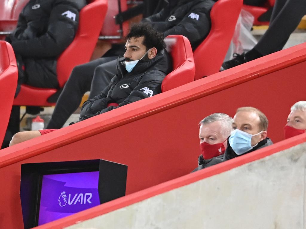 Liverpool's Egyptian midfielder Mohamed Salah sits in the stands after being substituted. (Photo by Laurence Griffiths / POOL / AFP)