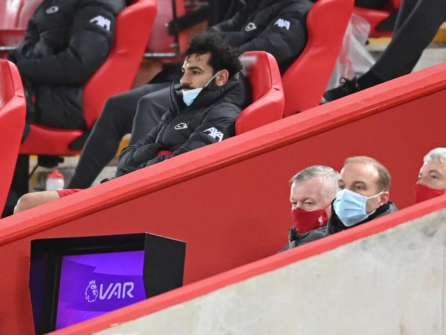 Liverpool's Egyptian midfielder Mohamed Salah sits in the stands after being substituted. (Photo by Laurence Griffiths / POOL / AFP)