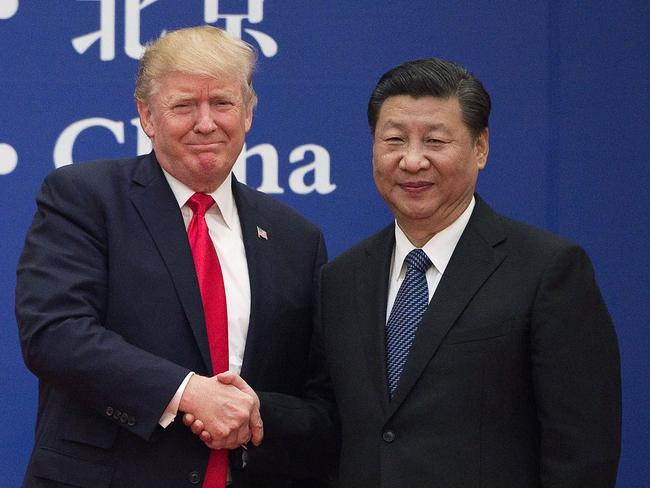 (FILES) This file photo taken on November 9, 2017 shows US President Donald Trump (L) and China's President Xi Jinping shaking hands during a business leaders event at the Great Hall of the People in Beijing. - Donald Trump's first term in office has been rough on China, with war over trade and tech amplified by daily mudslinging, yet Beijing may welcome his re-election as it scans the horizon for the decline of its superpower rival. (Photo by Nicolas ASFOURI / AFP) / TO GO WITH US-vote-diplomacy-trade-China,FOCUS by Patrick Baert