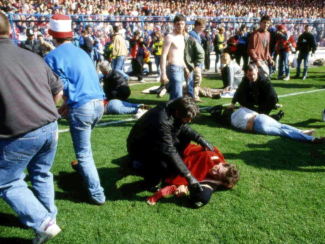 Stewards and supporters tend and care for wounded supporters on the field at Hillsborough Stadium, April 15, 1989. Picture: AP