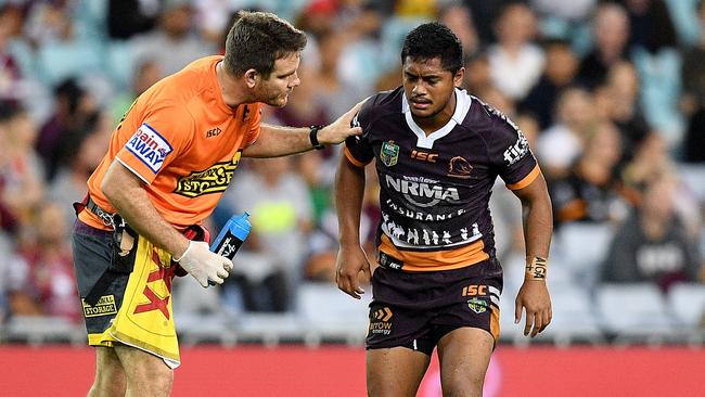 Anthony Milford of the Broncos receives attention from a trainer after a late shoulder charge from George Burgess of the Rabbitohs.