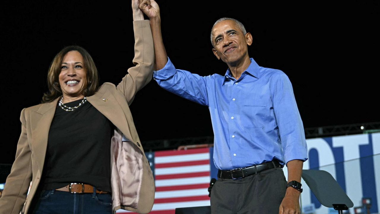 Former US President Barack Obama holds hands with US Vice President and Democratic presidential candidate Kamala Harris during a campaign rally at the James R Hallford Stadium in Clarkston, Georgia on October 24, 2024. (Photo by Drew ANGERER / AFP)