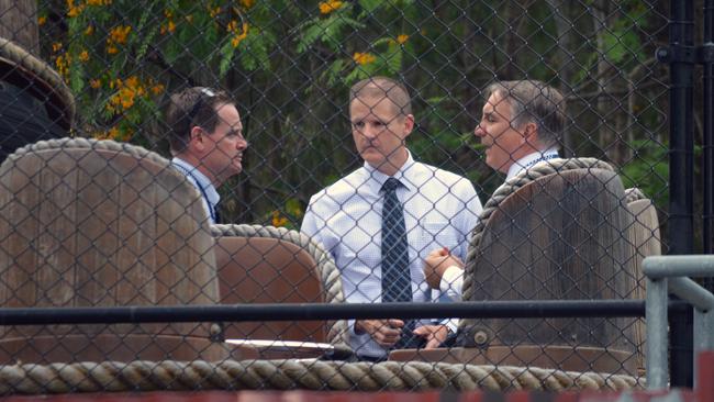 Police detectives are seen behind one of the rafts from the Thunder River Rapids ride at Dreamworld