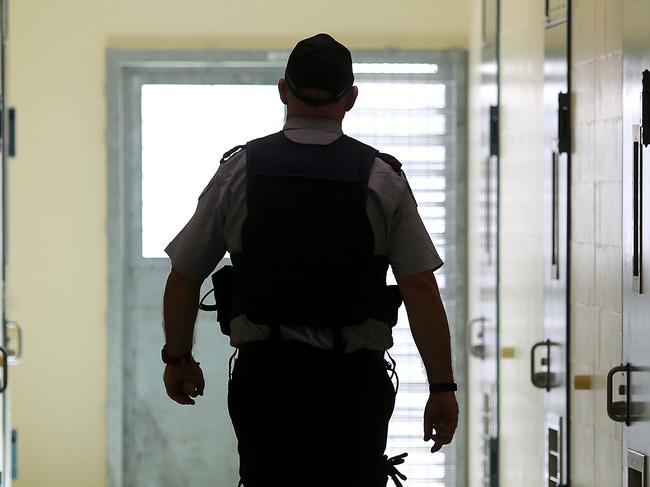 A corrections officer walks down a cell corridor. Prison stock at Borallon Correctional Centre, in Brisbane, Tuesday July 3, 2018. (AAP Image/Jono Searle) NO ARCHIVING