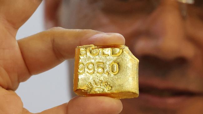 A jeweller displays a bar of gold at his shop in Kuwait City on October 21, 2024. (Photo by YASSER AL-ZAYYAT / AFP)