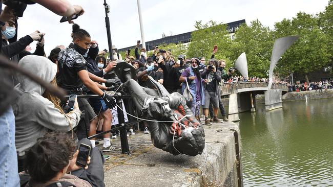 Protesters throw the statue of slave trader Edward Colston into Bristol harbour on June 7. Picture: AP