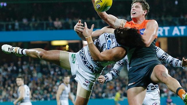 Is it a beard, is it a plane? No, it’s a flying Jimmy Bartel spoiling young Giant Jacob Hopper at Simonds Stadium. Picture: Michael Klein