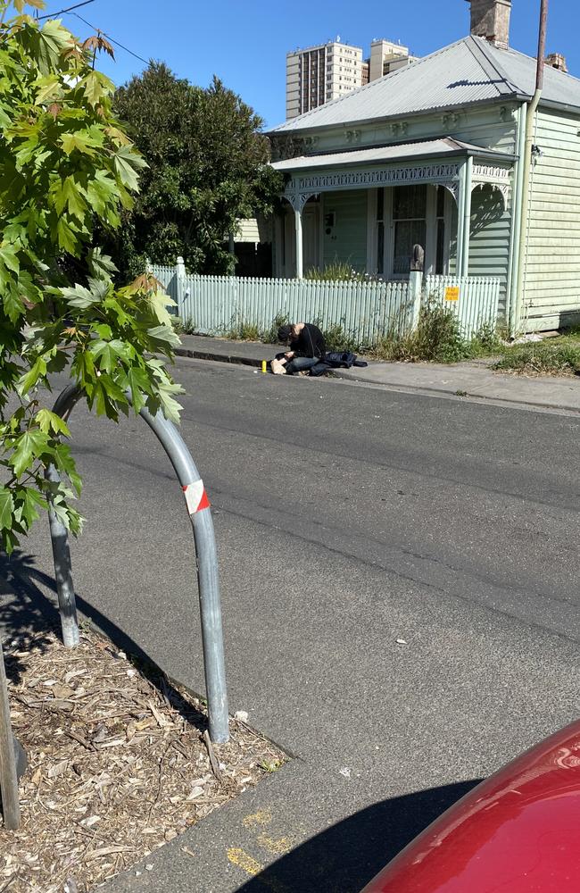 A drug user sits in the gutter with a needle sticking out of their arm. Picture: Steve Price