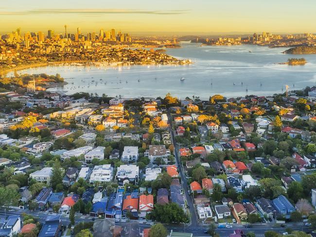 Wealthy Eastern suburbs of Sydney city around Harbour in aerial view with soft morning light and blue sky. Australian housing generic