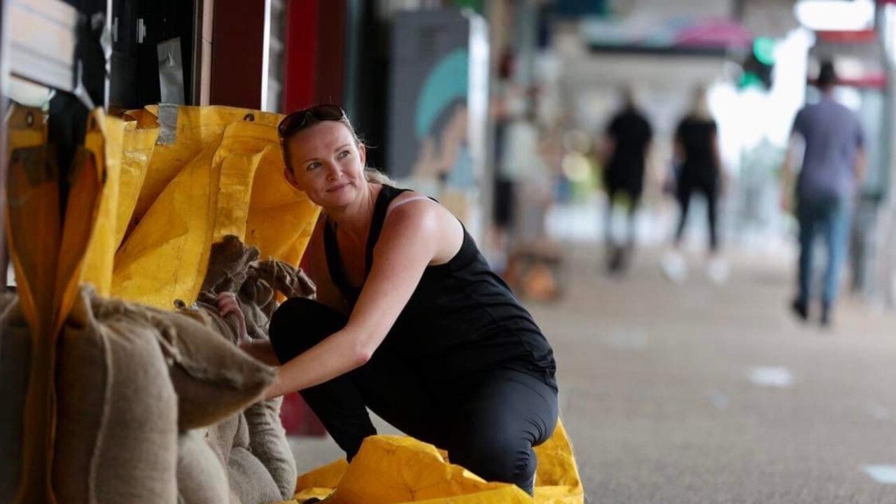 Kasey Hudson uses sandbags and tarp to try to protect her business.