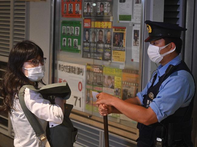 Tomoko Uraki, a member of Japanese lawyers network for refugees, is stopped by police outside the police station at Haneda airport where that Krystsina Tsimanouskaya was believed to have been taken on Sunday. Picture: AFP