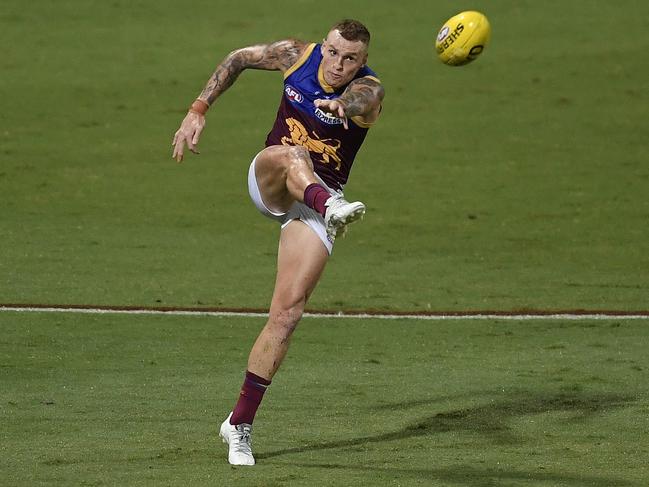 Lions favourite Mitch Robinson sends the ball downfield in the slippery conditions.