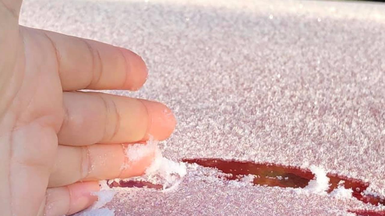 WINTER WEATHER: Mye Bautista scraps some frost off their car in Warwick as cooler temps come back in full force.