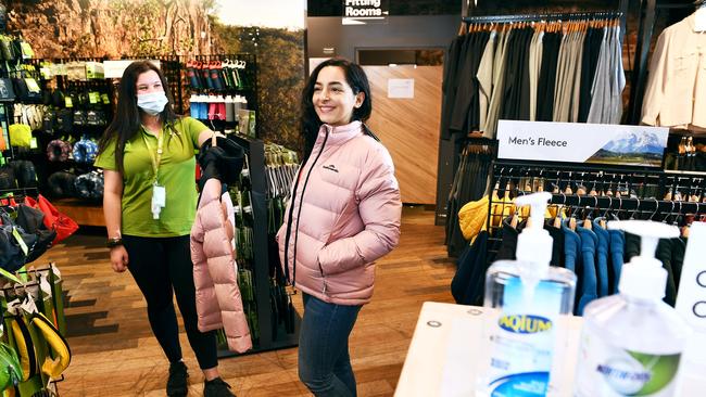 Customer Aysan Gholipoor tries on a jacket watched by sales advisor Elysse Dimitriadis at Katmandu in Rundle Mall Adelaide. Picture: Mark Brake