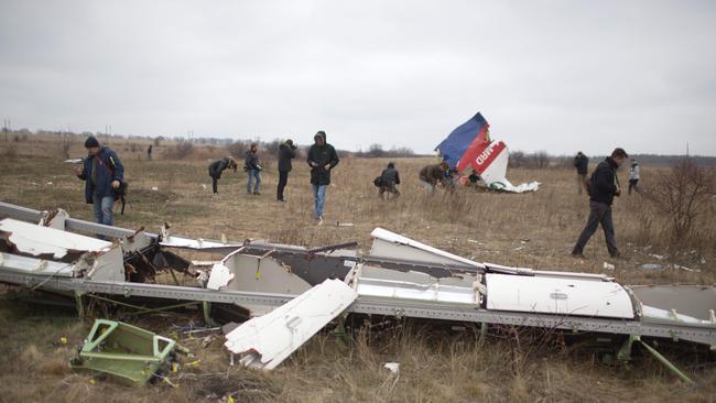 (FILES) In this file photo taken on November 11, 2014 Journalists look at parts of the Malaysia Airlines plane Flight MH17 as Dutch investigators (unseen) arrive at the crash site near the Grabove village in eastern Ukraine, hoping to recover debris from the Malaysia Airlines plane which crashed in July, killing 298 people, in remote rebel-held territory east of Donetsk. - A Dutch court gives its verdict on November 17, 2022 in the trial of four men over the downing of Malaysia Airlines flight MH17 above Ukraine in 2014, as tensions soar over Russia's invasion eight years later. All 298 passengers and crew were killed when the Boeing 777 flying from Amsterdam to Kuala Lumpur was hit over separatist-held eastern Ukraine by what investigators say was a missile supplied by Moscow. (Photo by Menahem KAHANA / AFP)