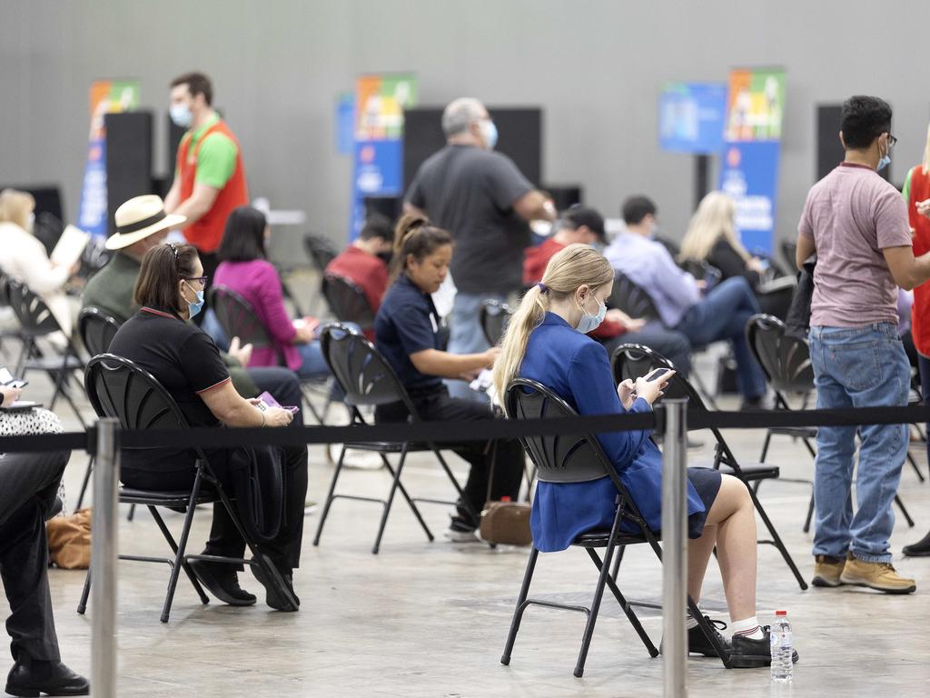 People wait after getting their Pfizer vaccine at the Convention and Exhibition Centre on the first day of opening. Picture: Sarah Marshall.