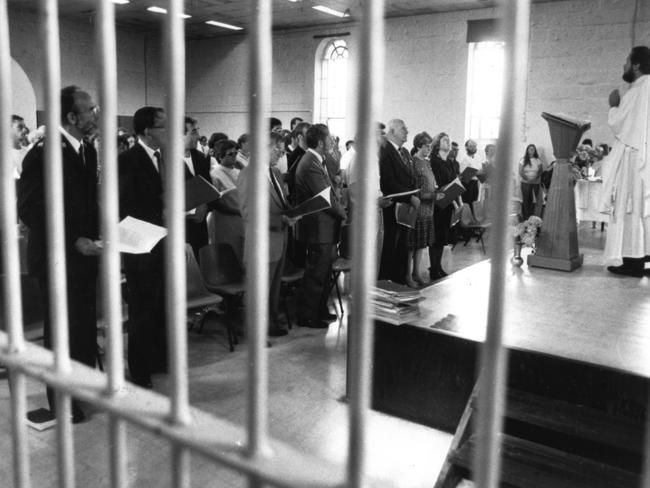 Prisoners and visitors rise for the Christmas Day service in the chapel at Pentridge Prison in 1985. 