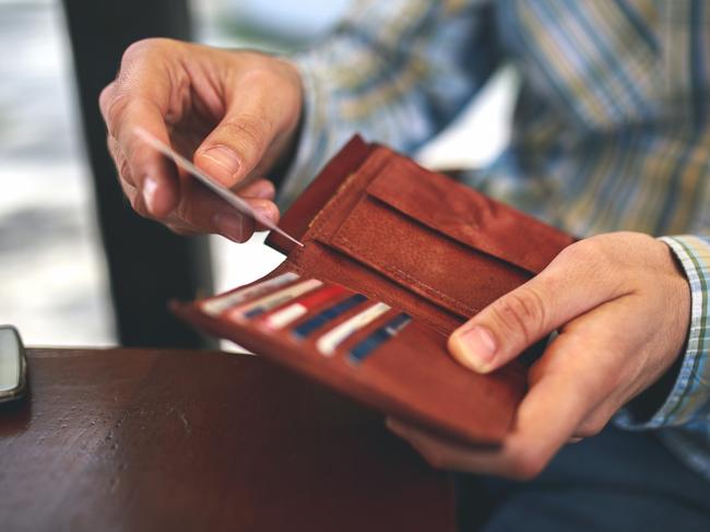 Man buys with a credit card. Generic photo of a wallet, credit cards, paying with credit card. Picture: Mixetto/ Istock