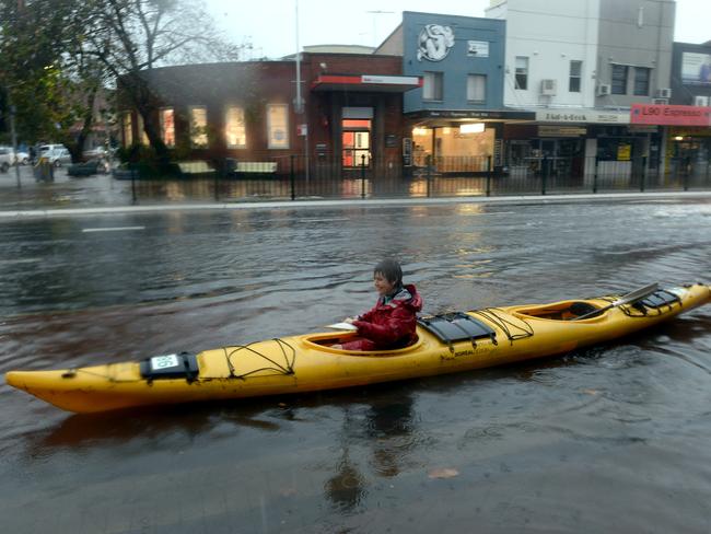 A woman paddles her kayak along Pittwater Road in Narrabeen. Julio Maio says he has not seen rains like it in 40 years of living on Sydney’s Northern Beaches. Photo Jeremy Piper