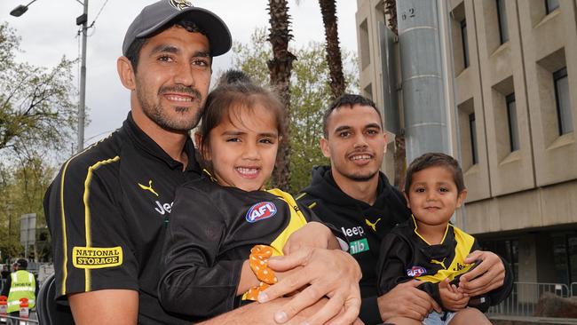 Marlion Pickett holds his daughter Shaniqua as Sydney Stack holds Pickett’s son Levi in the Grand Final parade.