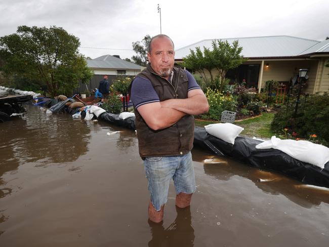 Mark Lia stands in the water he is trying to keep out of his home. Picture: David Caird