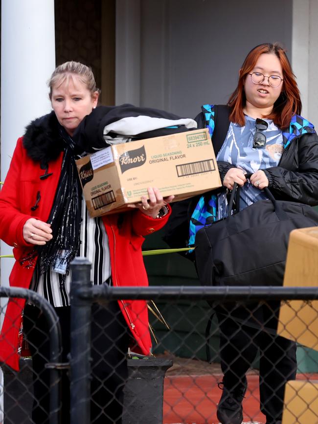 Baby Ronan’s mother Melanie Nguyen, right, leaves her Ottawa home with a police officer and packed bags. Picture: Kelly Barnes