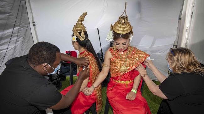 Emily Chi and Sitha Chan from the Santipheap Apsara Amatak Cambodian Dance Troupe being vaccinated for the first time by nurses Abraham Sang and Sharon Fitzmaurice at a pop-up Clinic outside the Multi Cultural Festival in Victoria Park. Picture: Emma Brasier.