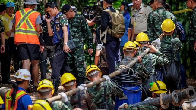 Military carry equipment into the Tham Luang Nang Non cave to continue the rescue operation. Picture: Getty Images.