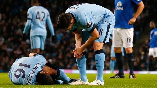 Manchester City's Argentinian striker Sergio Aguero (L) lies injured during the English Premier League football match between Manchester City and Everton at the Etihad Stadium in Manchester, north west England, on December 6, 2014. AFP PHOTO / LINDSEY PARNABY RESTRICTED TO EDITORIAL USE. No use with unauthorized audio, video, data, fixture lists, club/league logos or “live” services. Online in-match use limited to 45 images, no video emulation. No use in betting, games or single club/league/player publications.