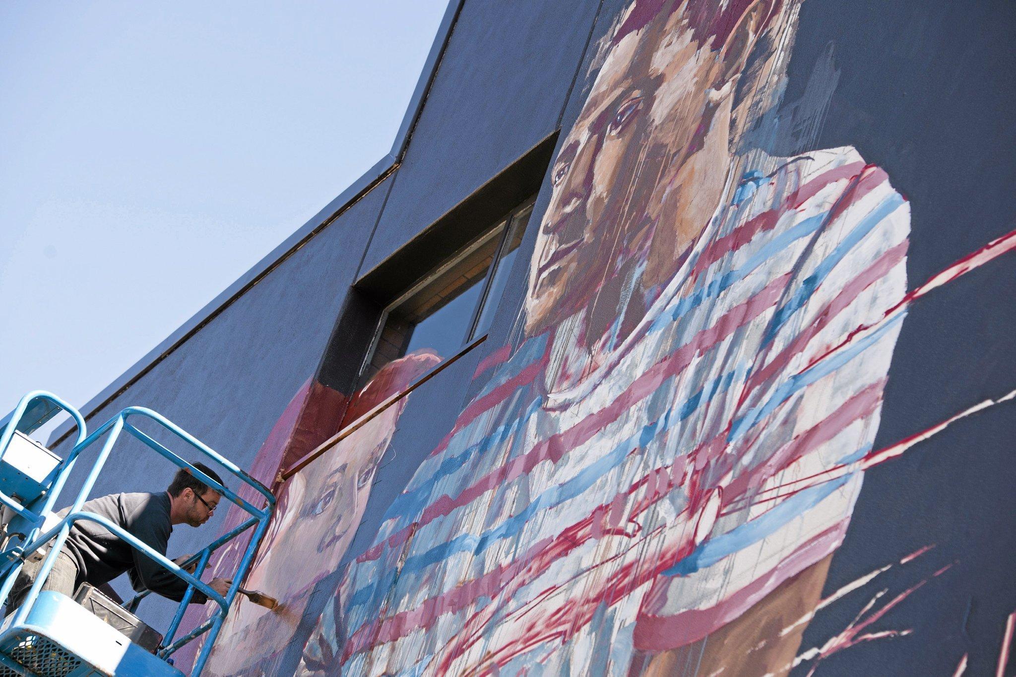 Fintan Magee paints on the SES building wall in Hume St car park for First Coat, Monday, May 30, 2016. Picture: Kevin Farmer